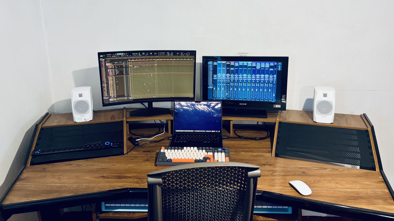 Estación de trabajo de Fonowong Home Studio: escritorio con dos pantallas, laptop y monitores de campo cercano.