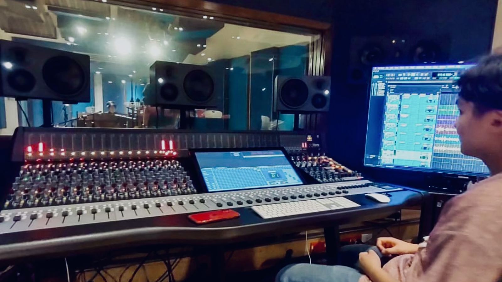 Tracking de batería en el estudio A: consola Neve Genesys Black y la cabina de grabación al otro lado del cristal.